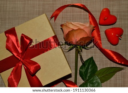 Gift box with red bow, pink rose and aroma candles white shape of heart. Top view