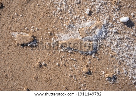beach sand in winter together with a bit of snow form an interesting background