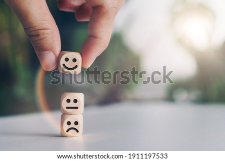 Smile face and cart icon on wood cube. Optimistic person or people feeling inside and service rating when shopping, satisfaction concept in business. Royalty-Free Stock Photo #1911197533