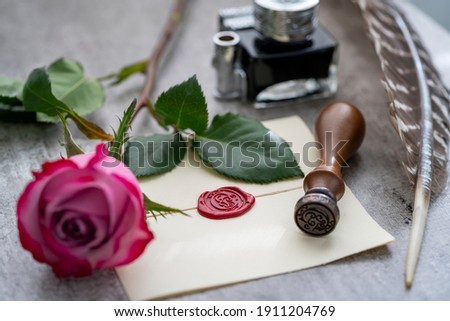 Romantic scene with vintage wax-sealed letter and pink rose. 