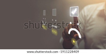 Businessman pressing angry face emoticon on virtual touch screen. Customer service evaluation concept. Royalty-Free Stock Photo #1911228409