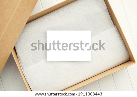 Empty white paper card mockup for design, business, shop or gift card in brown box, space for text.             