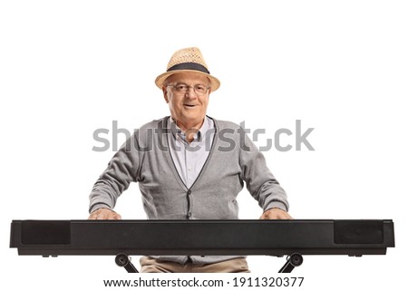 Elderly man sitting and playing a keyboard isolated on white background