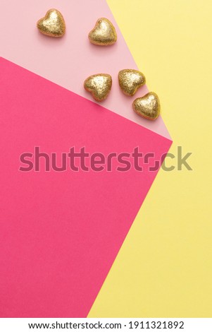 Abstract minimal composition with golden hearts on yellow and pink backround. Creative love, Valentines or Mother's day concept.
