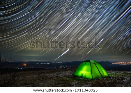 Long exposure tent on the background of the starry sky on the top of the mountain