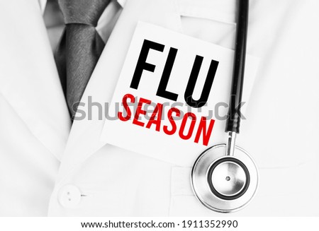 White sticker with text Flu Season lying on medical robe with a stethoscope