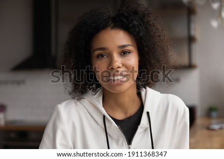 Portrait of smiling millennial african female fitness trainer looking at camera holding webinar promoting healthy lifestyle. Pretty young black woman confident teacher coach speak give virtual lesson