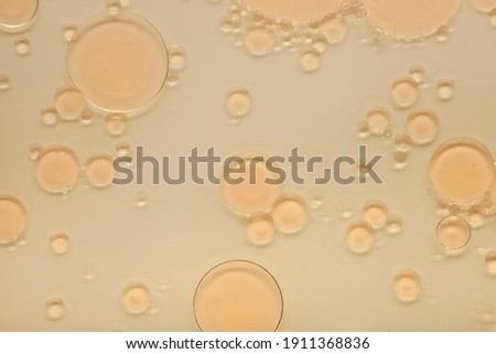 Cosmetic liquid texture with oil drops. Toner. Extract. Serum. Yellow bi-phase cleanser. Royalty-Free Stock Photo #1911368836