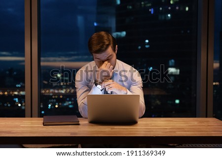 Need some rest. Overworked young man ceo manager take break in online work close tired eyes rub nose bridge. Busy office employee suffer from chronic dry eye syndrome spending hours in front of laptop Royalty-Free Stock Photo #1911369349