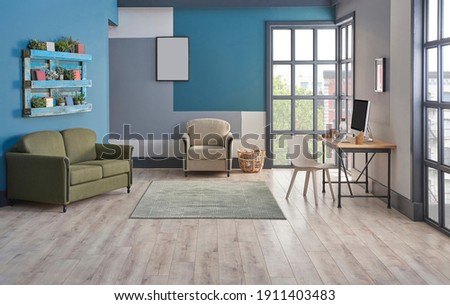 Decorative blue and grey wall background, home decoration interior style with sofa carpet middle table frame and working desk style.