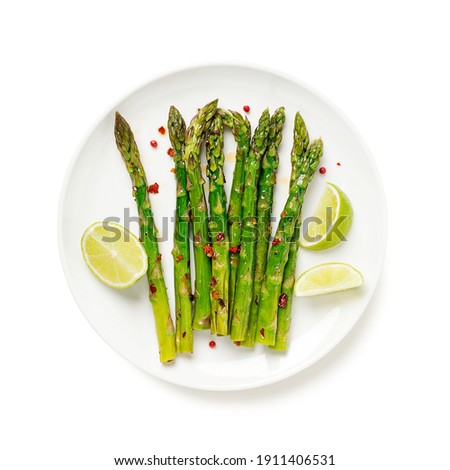 Grilled organic asparagus with lemon on white plate .isolated on white background.top view Royalty-Free Stock Photo #1911406531