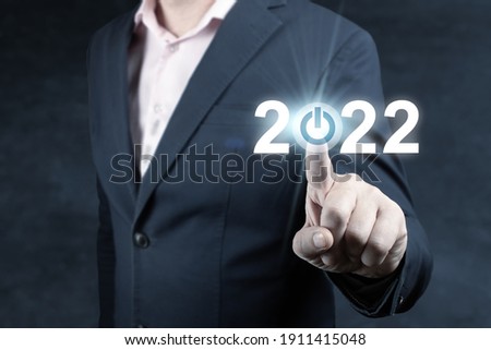 Businessman pressing 2022 start up business. Press the start button. Business and Technology target set goals and achievement in 2022 new year resolution, planning and start up strategies and ideas