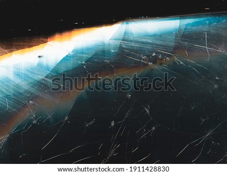 Damaged screen background. Fractured texture. Dark weathered dirty wreck faded display matrix with dust scratches smeared stains noise colorful rainbow lens flare.