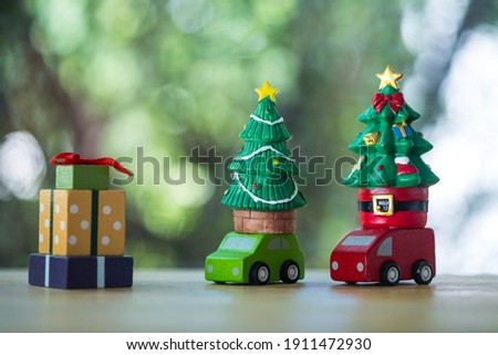 Green car and red car with Christmas tree arriving gift box. Christmas holiday celebration concept