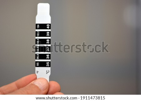 Fast Check Forehead Thermometer Strip. for Home or School. Reusable Color Change Bands Monitor Fever and Temperature of Infants, Babies, Toddlers and Kids. Quick Read in Celsius and Fahrenheit Scales Royalty-Free Stock Photo #1911473815