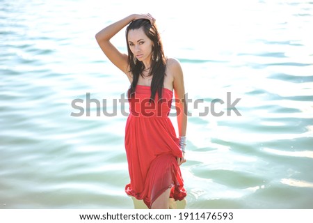 lifestyle photo of woman with perfect hair.walking alone at the beach.Sensual young girl relaxing.Colorful filter.glam style,teen trend outfit, positive mood,smiling,amazing model girl,long hair Royalty-Free Stock Photo #1911476593