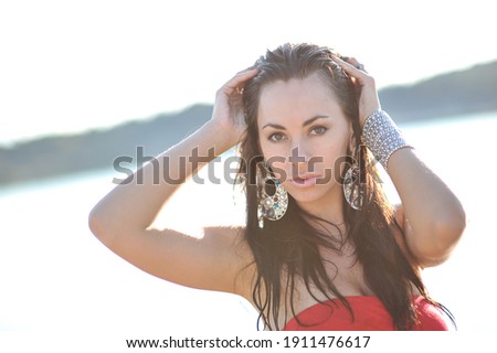 lifestyle photo of woman with perfect hair.walking alone at the beach.Sensual young girl relaxing.Colorful filter.glam style,teen trend outfit, positive mood,smiling,amazing model girl,long hair Royalty-Free Stock Photo #1911476617
