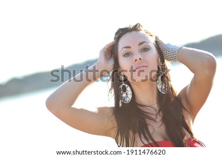 lifestyle photo of woman with perfect hair.walking alone at the beach.Sensual young girl relaxing.Colorful filter.glam style,teen trend outfit, positive mood,smiling,amazing model girl,long hair Royalty-Free Stock Photo #1911476620