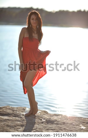 lifestyle photo of woman with perfect hair.walking alone at the beach.Sensual young girl relaxing.Colorful filter.glam style,teen trend outfit, positive mood,smiling,amazing model girl,long hair Royalty-Free Stock Photo #1911476638