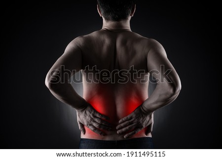 Back pain, kidney inflammation, ache in man's body on black background, painful area highlighted in red Royalty-Free Stock Photo #1911495115