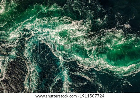 Waves of water of the river and the sea meet each other during high tide and low tide. Whirlpools of the maelstrom of Saltstraumen, Nordland, Norway Royalty-Free Stock Photo #1911507724