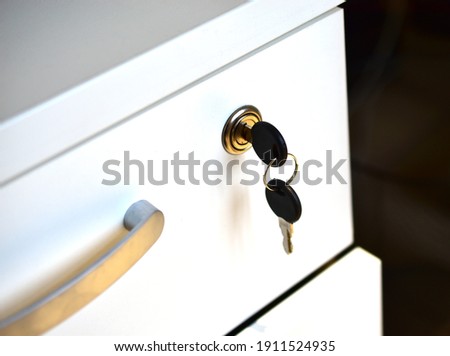 White office nightstand with a key in the lock
