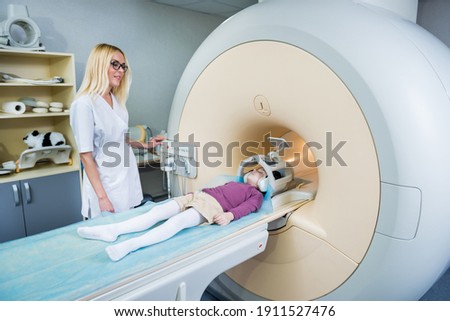 Radiologist prepares the little girl for an MRI brain examination