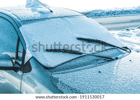 Frosted windshield of a car on a winter morning. A protective mat does protect against to frost on the windshield. Royalty-Free Stock Photo #1911530017