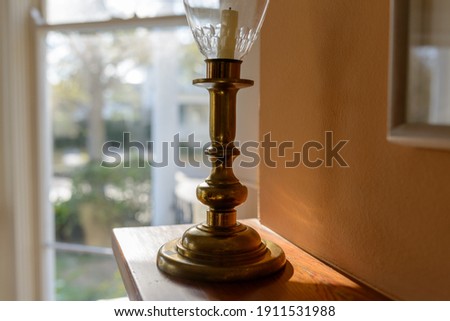 Selective focus of antique brass candlestick on fireplace mantle