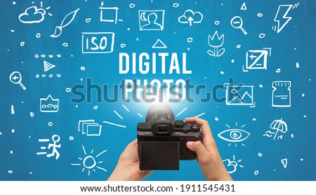 Hand taking picture with digital camera and DIGITAL PHOTO inscription, camera settings concept