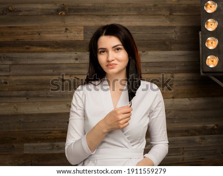 female doctor in a white uniform takes off with a black medical mask stands on a wooden background with a copy of the space Royalty-Free Stock Photo #1911559279