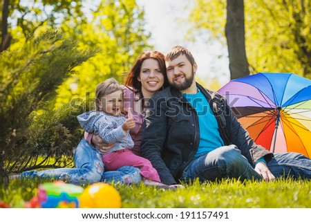 mother and father are plaing with their daughter in the park