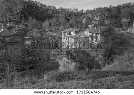 View of the river with old cereal mills in ancient medieval village of Rupit , near Pyrenees , Spain.Travel landscape concept background in black and white style..