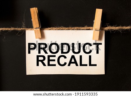 a sheet on a black background with text PRODUCT RECALL . business concept