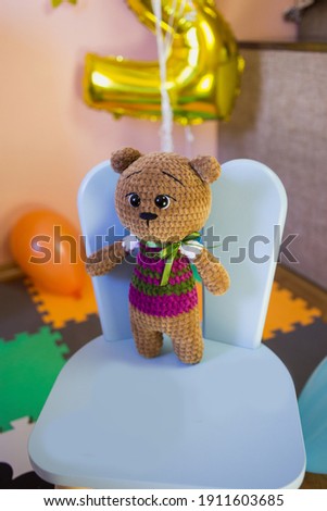 Knitted bear against the background of a children's holiday - birthday.