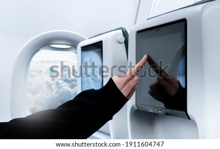 Detail of airplane interior with the touch screen monitor in-flight entertainment  Royalty-Free Stock Photo #1911604747