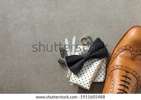 Grooms wedding day preparation. cufflinks, shoe, rings and bow tie background Royalty-Free Stock Photo #1911605488