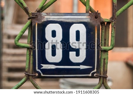 Weathered grunge square metal enameled plate of number of street address with number 89