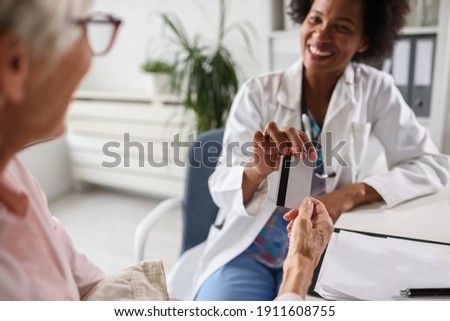 Medical worker taking credit card for medical bill. focus on card. Royalty-Free Stock Photo #1911608755