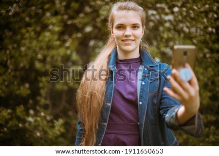 A girl takes a selfie on her phone