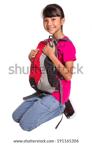 A young Asian Malay girl with a backpack over white background