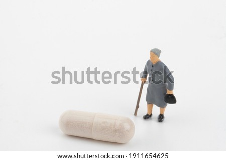old people miniatures with medicine pills 