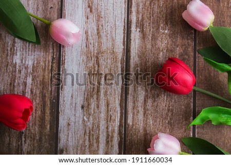 Pink and red tulips on a brown wooden background. Background for design. Spring background. Mother's Day. Women's Day. Spring day. Easter background. Easter. Copy space.