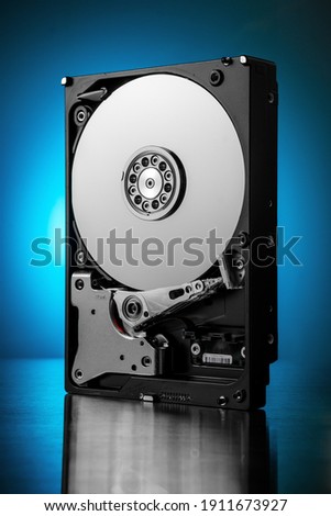 Inside of hard disk drive on the metal brushed background. Royalty-Free Stock Photo #1911673927