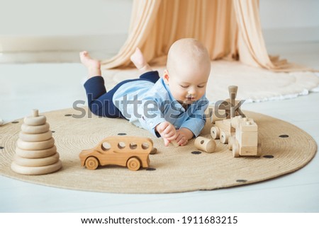 Baby playing with wooden toys. Eco-friendly wooden toys for children Royalty-Free Stock Photo #1911683215