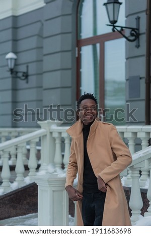 young African American in winter against the backdrop of a majestic building. High quality photo