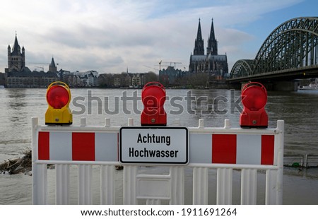 Extreme weather: Warning sign in German at the entrance to a flooded pedestrian zone in Cologne, Germany Royalty-Free Stock Photo #1911691264