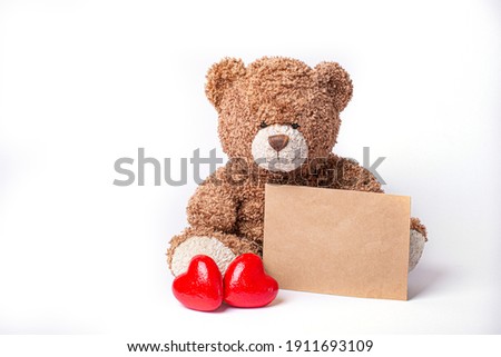 Teddy bear holds a letter from a lover isolated on a white background