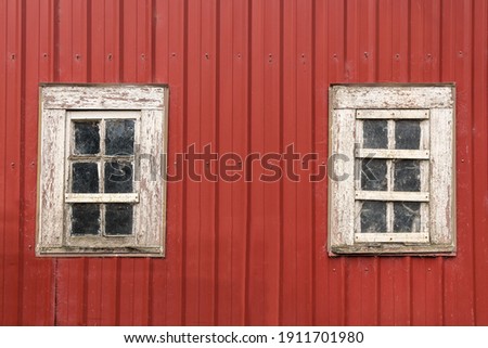 Old Red Barn with Two Weathered White Wooden Windows, Peeling Paint and Spider Webs. Royalty-Free Stock Photo #1911701980