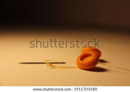  yellow buttons and sewing needle